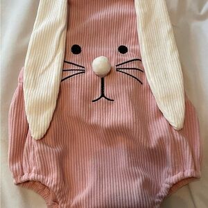 Bunny Baby pink ribbed Onesie. Cream ears. Pom nose. Straps in back.